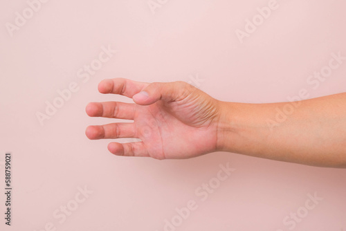 Empty hand showing gesture holding something like bottle or glass of water isolated on pink background.