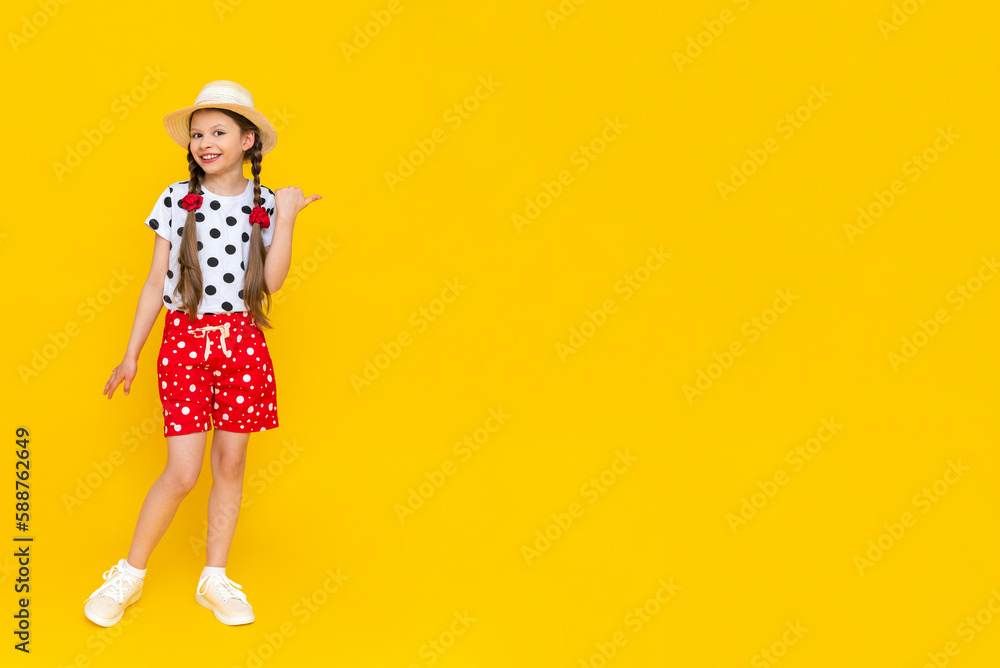 A beautiful girl dressed in summer clothes, red polka dot shorts, a place to copy on a yellow background. A beautiful girl dressed in summer clothes, red polka dot shorts, a place to copy on a yellow background.