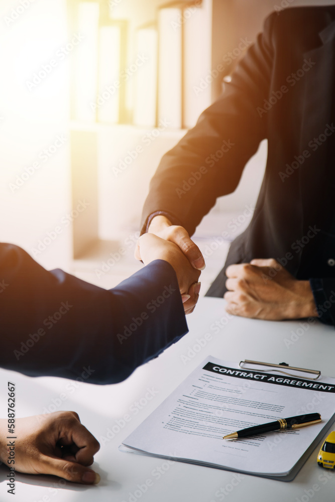 A car rental company employee is handing out the car keys to the renter after discussing the rental details and conditions together with the renter signing a car rental agreement. Concept car rental. - obrazy, fototapety, plakaty 