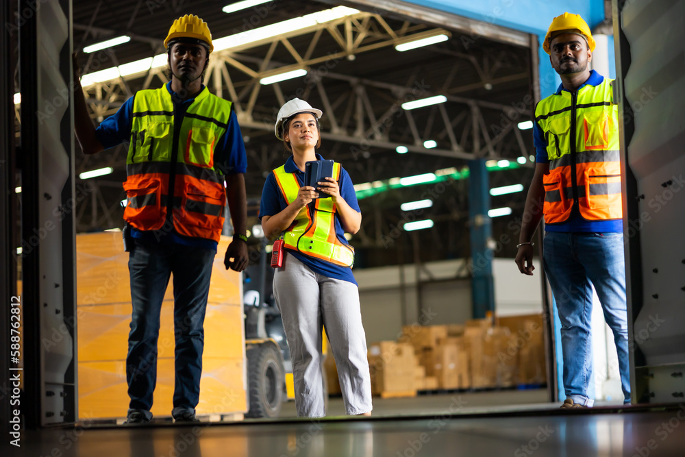 Fototapeta premium Group of warehouse asian indian workers wearing safety hardhats helmet inspection in container at warehouse. E-Commerce Goods at Logistics Warehouse factory.warehouse interior with shelves, pallets 