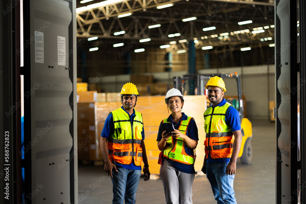 Group of warehouse asian indian workers wearing safety hardhats helmet inspection in container at warehouse. E-Commerce Goods at Logistics Warehouse factory.warehouse interior with shelves, pallets Group of warehouse asian indian workers wearing safety hardhats helmet inspection in container at warehouse. E-Commerce Goods at Logistics Warehouse factory.warehouse interior with shelves, pallets