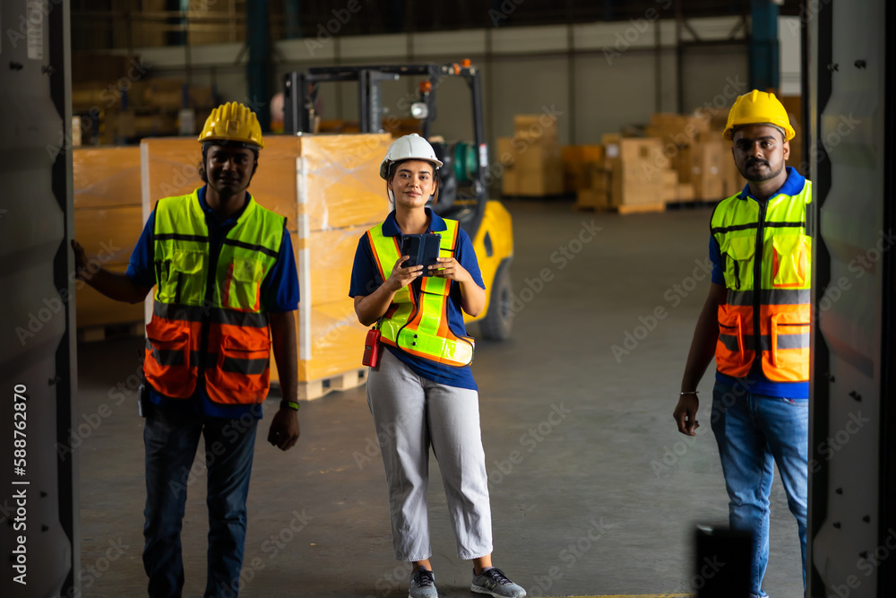 Group of warehouse asian indian workers wearing safety hardhats helmet inspection in container at warehouse. E-Commerce Goods at Logistics Warehouse factory.warehouse interior with shelves, pallets Group of warehouse asian indian workers wearing safety hardhats helmet inspection in container at warehouse. E-Commerce Goods at Logistics Warehouse factory.warehouse interior with shelves, pallets