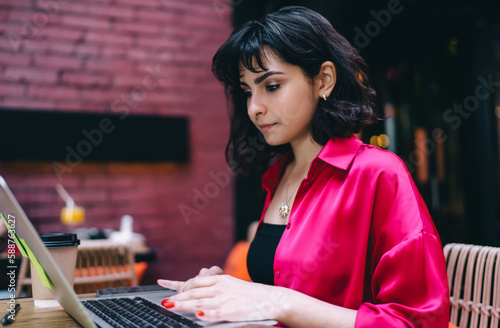 Focused woman working on laptop in cafe