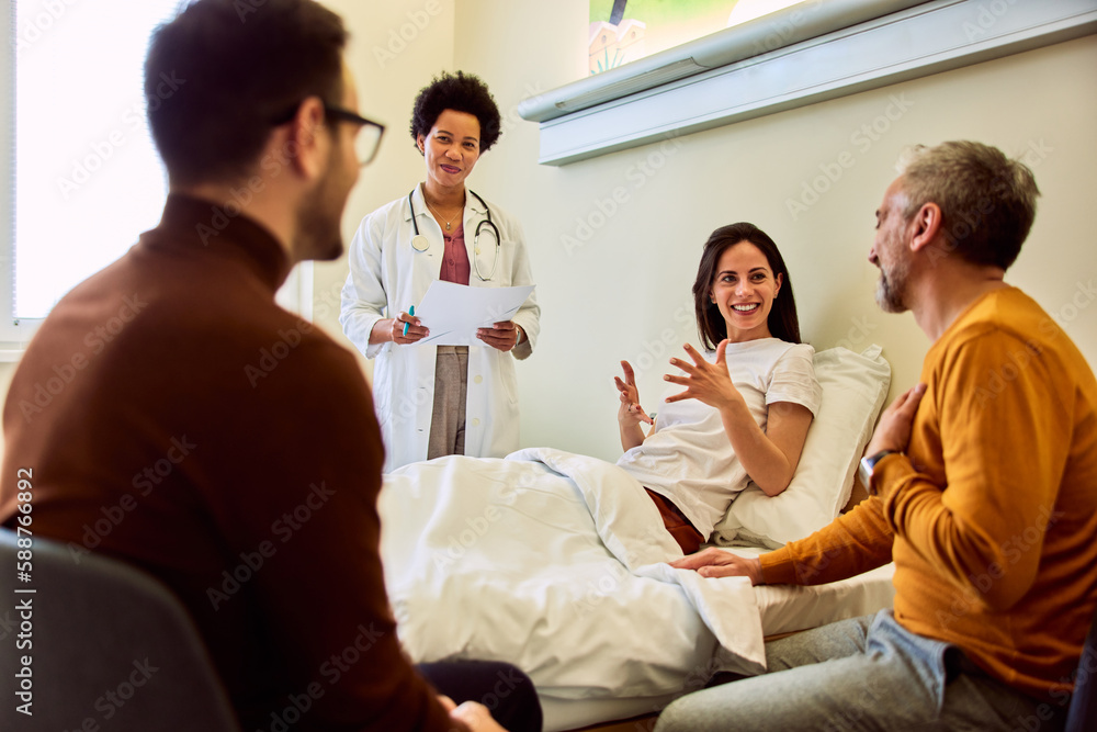 A smiling female patient talked with her father during the visit to the hospital. A smiling female patient talked with her father during the visit to the hospital.