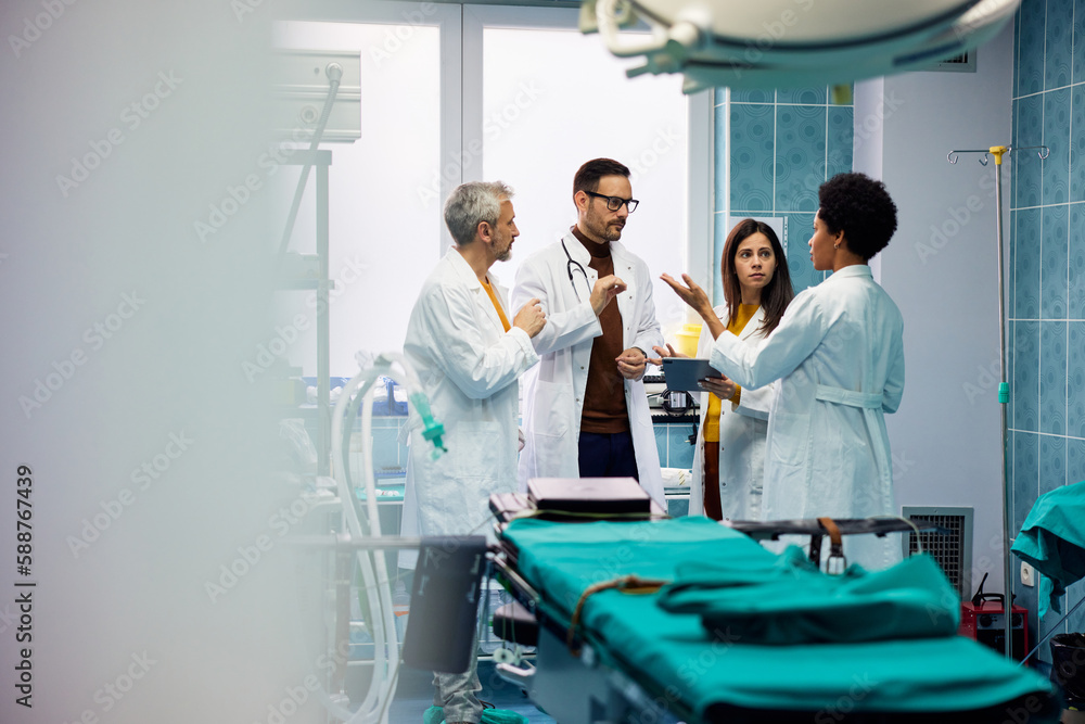 Obraz premium A female African-American doctor talking and discussing with her male and female colleagues.