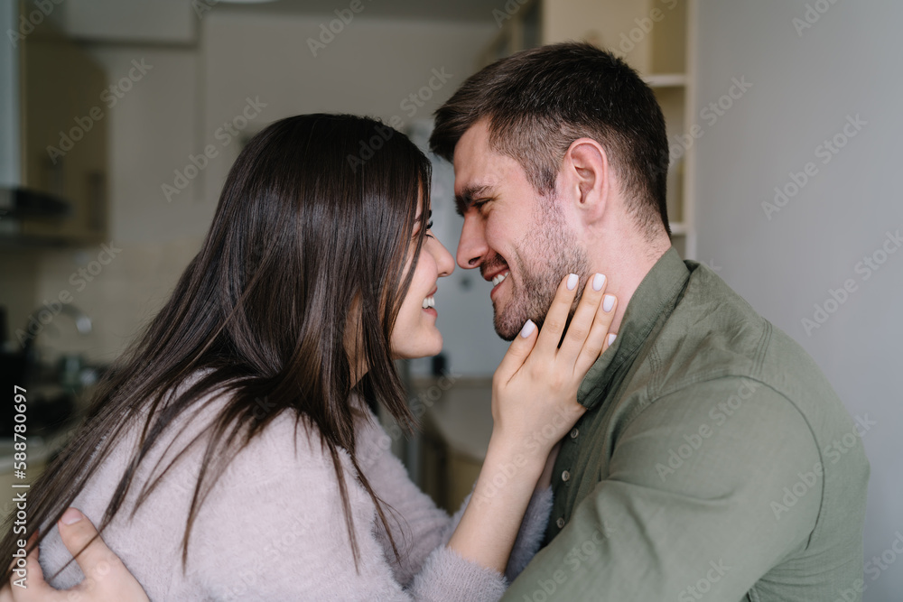 Happy couple looking into eyes in kitchen Happy couple looking into eyes in kitchen