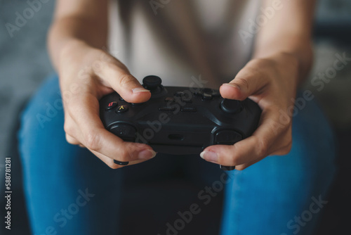 Close-up view of a woman s hands holding a joystick and playing video games. For lifestyle design. Computer entertainment. Computer gaming.