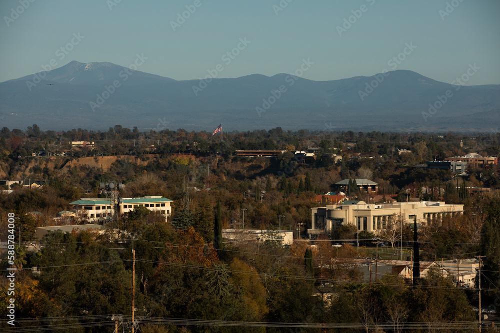Redding, California, USA - November 22, 2021: Late afternoon sun shines on downtown Redding skyline with a mountain backdrop.