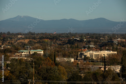 Redding, California, USA - November 22, 2021: Late afternoon sun shines on downtown Redding skyline with a mountain backdrop.