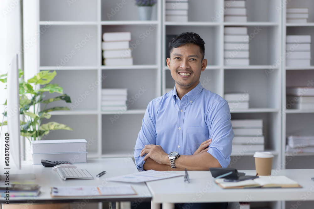 Young Asian businessman looking camera with arms crossed smiling happy at the office. Young Asian businessman looking camera with arms crossed smiling happy at the office.