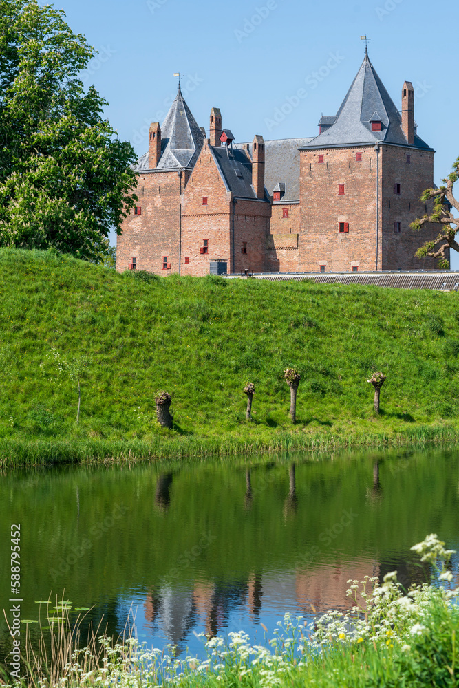 Captivating view across the moat water over the dike to Slot Loevestein Castle and its rich history. The fortress is the most famous in the Netherlands.