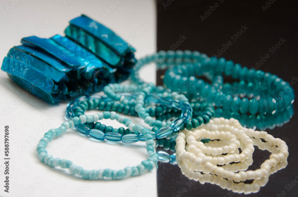 Fototapeta premium Blue and white beaded bracelets on the white and mirror surface