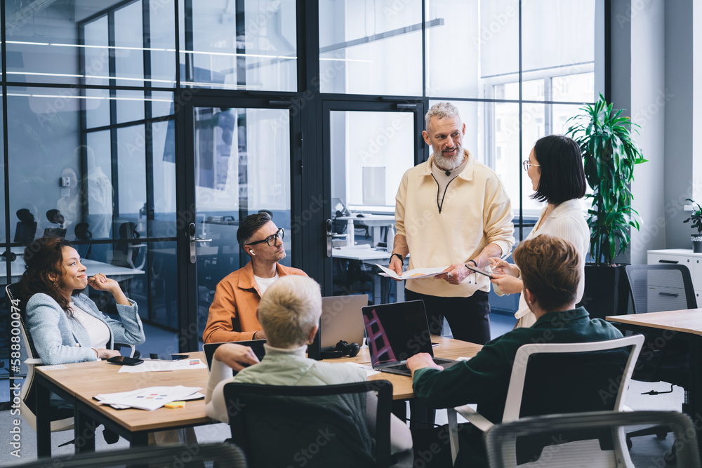 Confident multiethnic colleagues having conversation in office Confident multiethnic colleagues having conversation in office