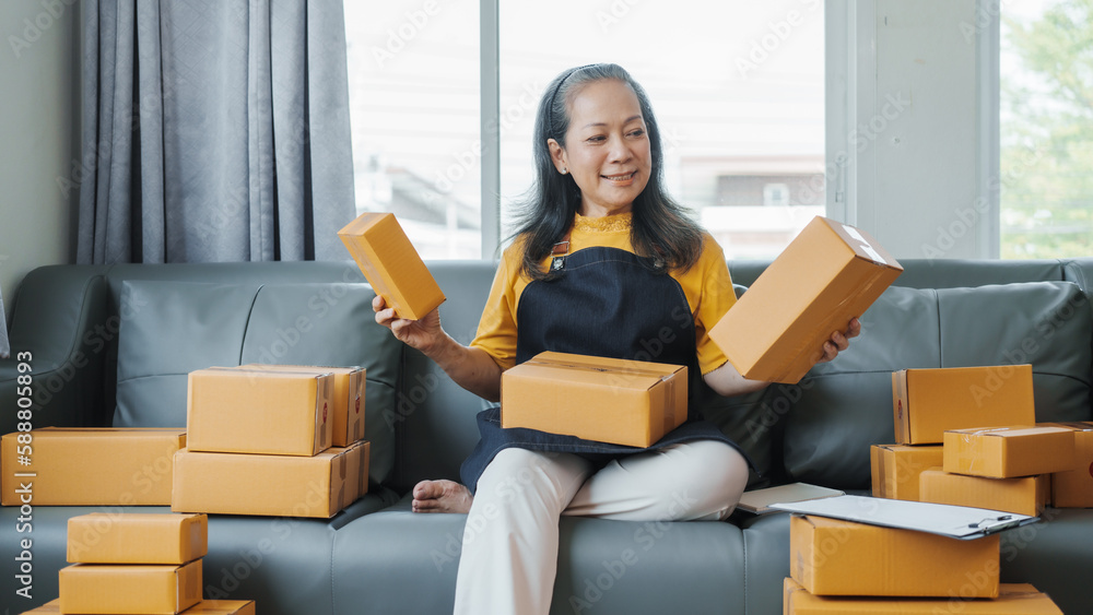 Successful asia people woman entrepreneur with parcel boxes checking email order in tablet and laptop at sofa home office SMEs small company. Successful asia people woman entrepreneur with parcel boxes checking email order in tablet and laptop at sofa home office SMEs small company.