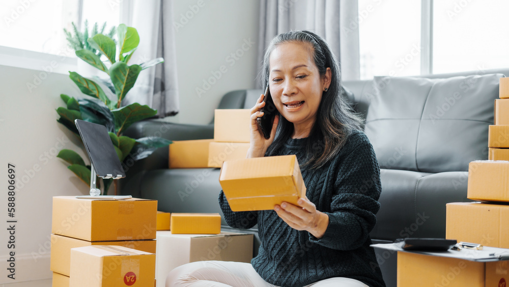 Successful asia people woman entrepreneur with parcel boxes checking email order in tablet and laptop at sofa home office SMEs small company. Successful asia people woman entrepreneur with parcel boxes checking email order in tablet and laptop at sofa home office SMEs small company.