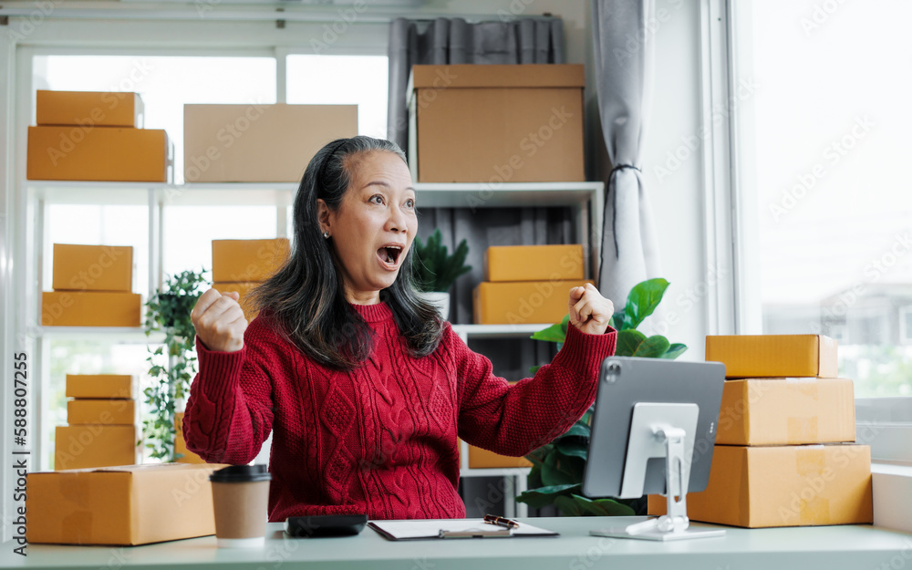 Successful asia people woman entrepreneur with parcel boxes clothing online store checking email order in tablet and laptop at sofa home office SMEs small company. Successful asia people woman entrepreneur with parcel boxes clothing online store checking email order in tablet and laptop at sofa home office SMEs small company.