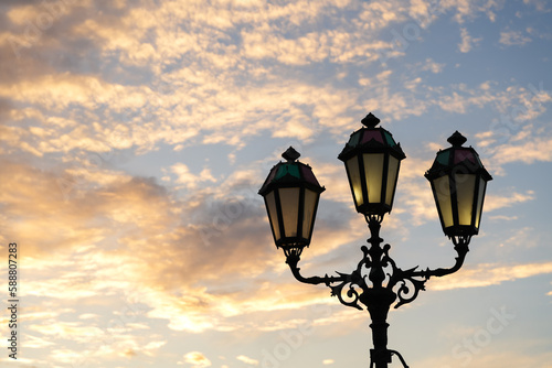 A lot of vintage street lamps against dusk sky in a sea harbour