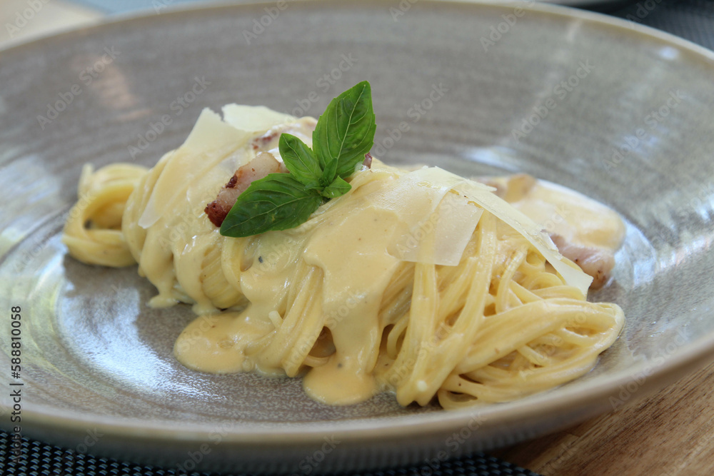 Spaghetti carbonara with fried pork in grey ceramic bowl Spaghetti carbonara with fried pork in grey ceramic bowl