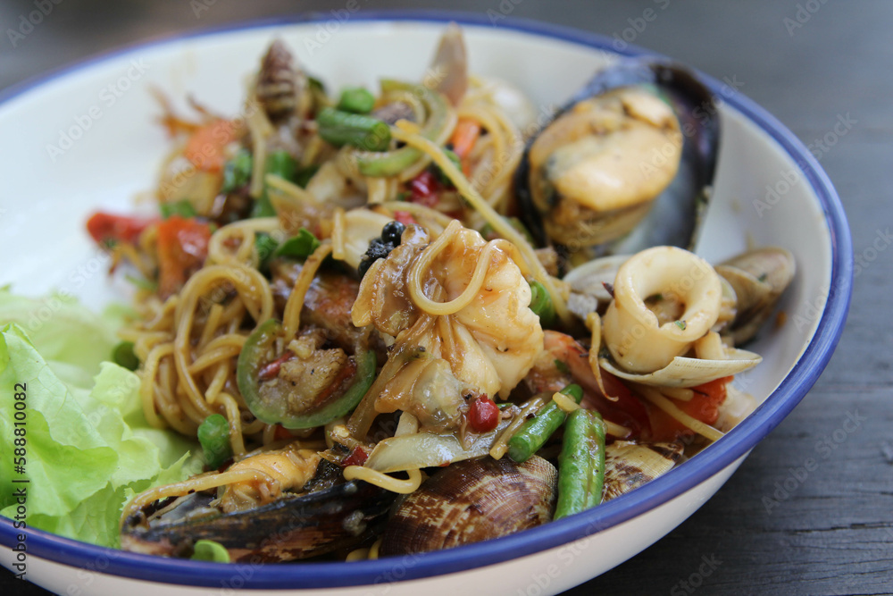 Stir fried spaghetti seafood on white ceramic plate