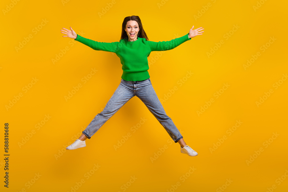 Full body portrait of satisfied pretty lady jumping raise hands good mood isolated on yellow color background
