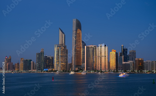 Blue hour cityscape with the skyline of Abu Dhabi. Travel to United Arab Emirates, view to modern skyscraper office buildings.
