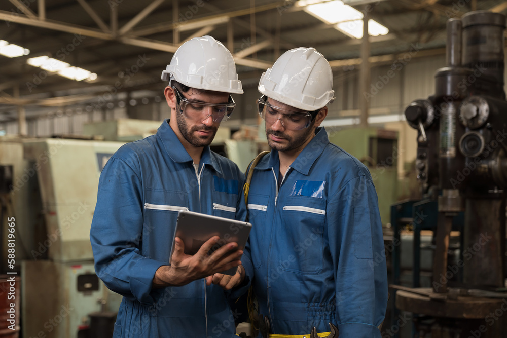 Group of male factory worker maintenance machine in industrial factory, working with digital tablet computer. Male technician inspecting lathe machine. Male engineer repairing machine in workshop Group of male factory worker maintenance machine in industrial factory, working with digital tablet computer. Male technician inspecting lathe machine. Male engineer repairing machine in workshop