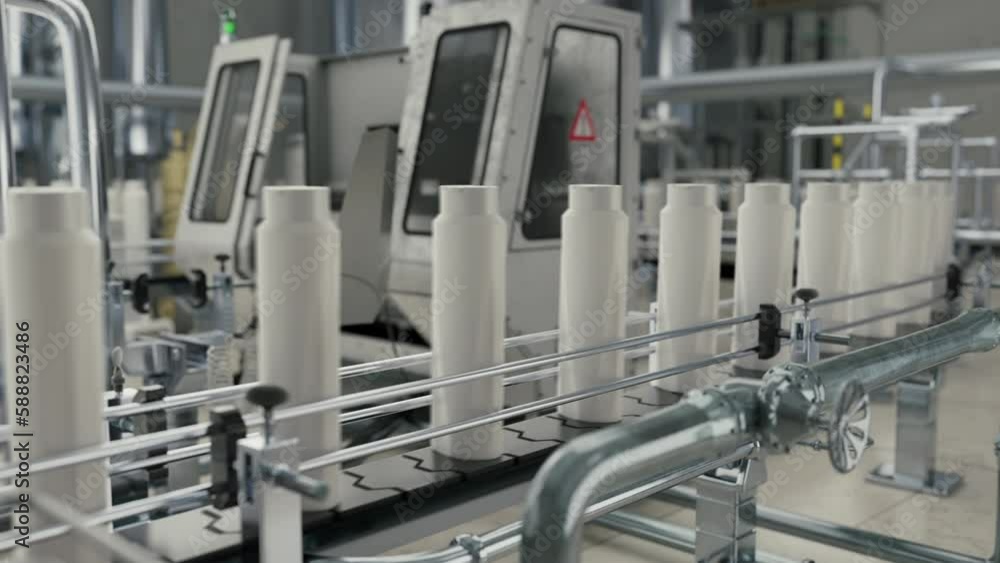 Automated industrial conveyor line sorting the shampoo bottles at the factory. Sorting the manufactured plastic shampoo bottles. Sorting the produced long shampoo bottles on the conveyor belt. Automated industrial conveyor line sorting the shampoo bottles at the factory. Sorting the manufactured plastic shampoo bottles. Sorting the produced long shampoo bottles on the conveyor belt.