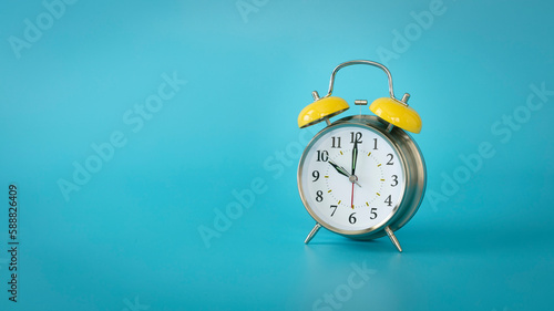 Retro silver alarm clock. 10:00, am, pm. Blue background.