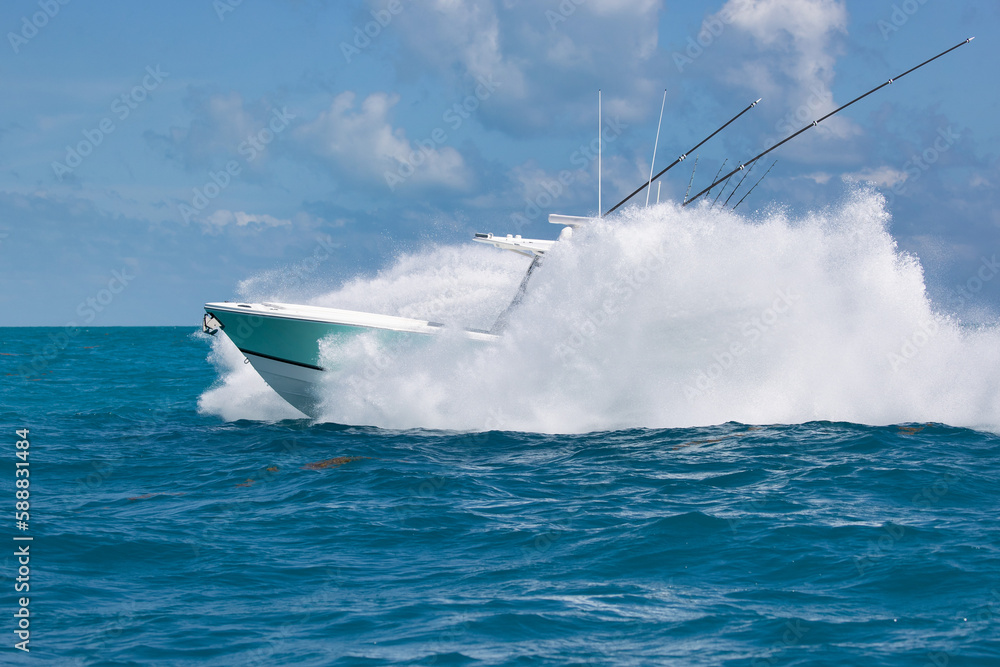 Fototapeta premium Speeding center console fishing boat almost hidden by spray.