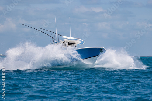 Center console fishing boat almost hidden by spray.