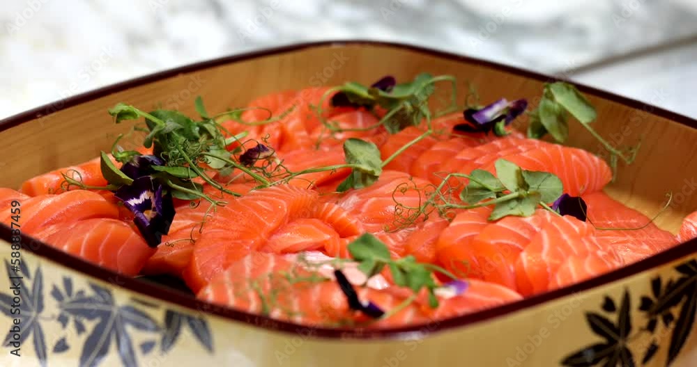 Freshly cut raw salmon fillet with natural herb garnish served as a gourmet seafood appetizer in a luxury restaurant. Healthy and delicious dish. Freshly cut raw salmon fillet with natural herb garnish served as a gourmet seafood appetizer in a luxury restaurant. Healthy and delicious dish.