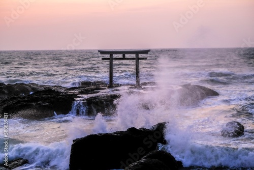 a floating tori gate at sunset, japanese, ocean waves breaking at sunset over a wooden tori gate, 