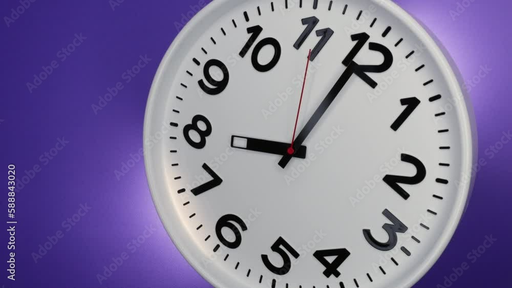 A White Wall Clock On Purple Background With A Time Of 8.00 Am Or Pm. A Black Hands and Red Second Hand Of The Clock. 4k. ProRes. A White Wall Clock On Purple Background With A Time Of 8.00 Am Or Pm. A Black Hands and Red Second Hand Of The Clock. 4k. ProRes.