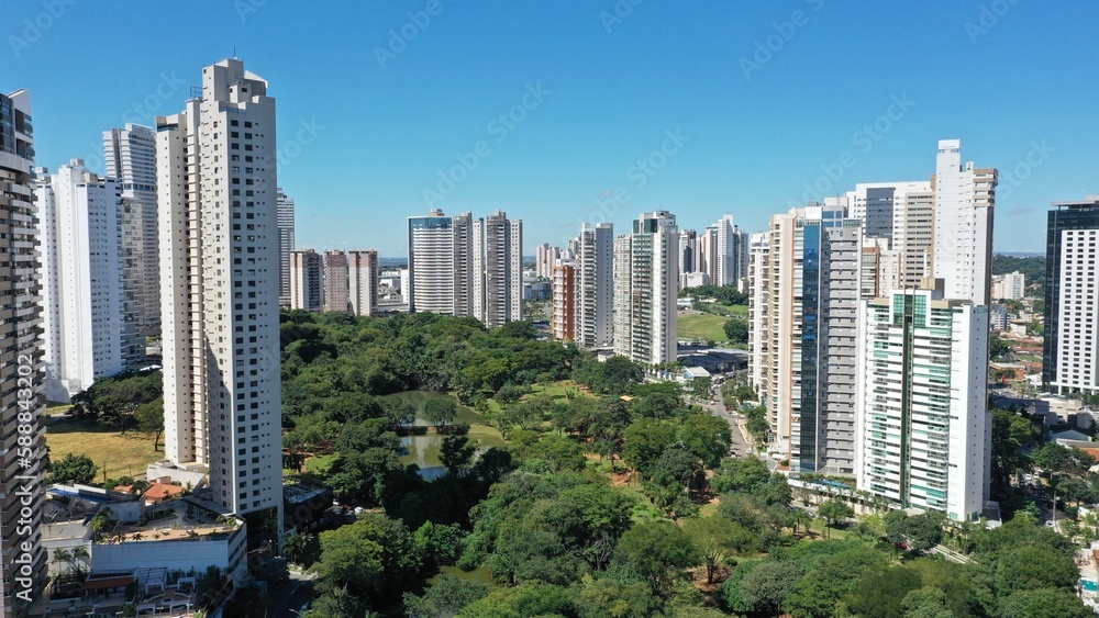 Wonderful panoramic view of Flamboyant Park with lakes and tropical trees surrounded by modern residential apartments in Goiania, Goias, Brazil in April, 2023. 
