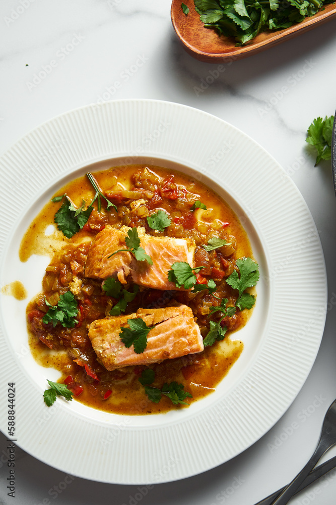Indian-Inspired Salmon: A Vibrant Red Curry with Juicy Tomatoes, and Fried Vegetables with Fresh Cilantro on the Side. Vertical photo Indian-Inspired Salmon: A Vibrant Red Curry with Juicy Tomatoes, and Fried Vegetables with Fresh Cilantro on the Side. Vertical photo