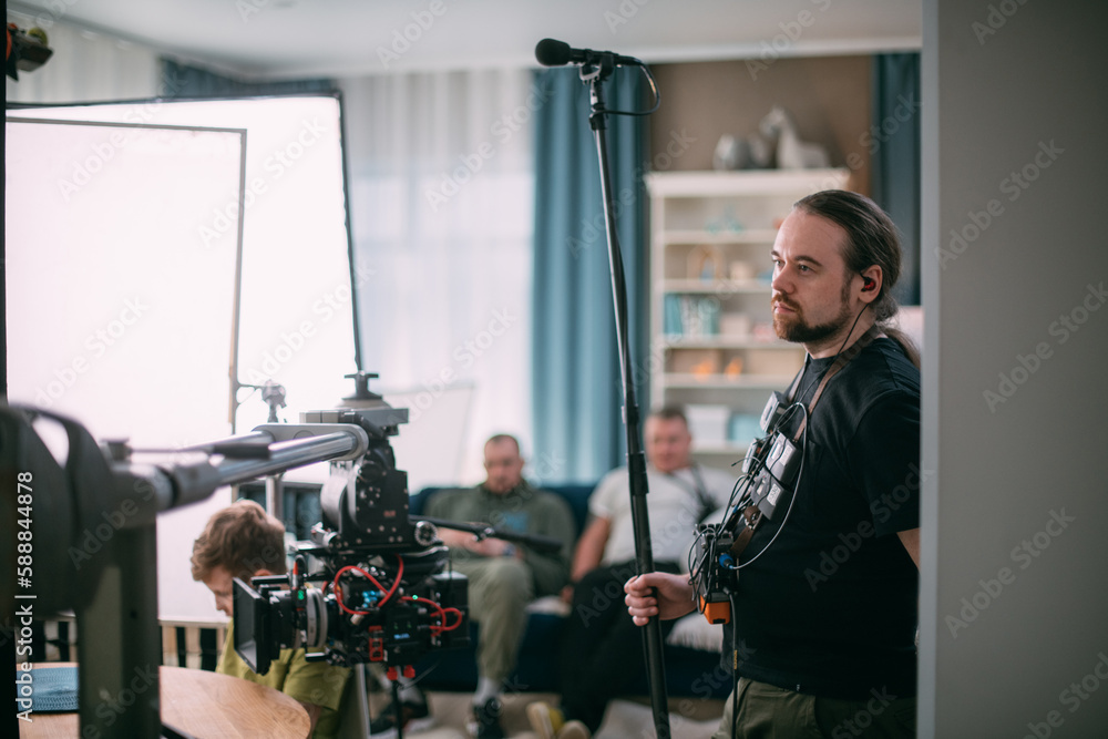 Sound engineer with a microphone on the set. A professional sound engineer at work on the filming of a movie Sound engineer with a microphone on the set. A professional sound engineer at work on the filming of a movie