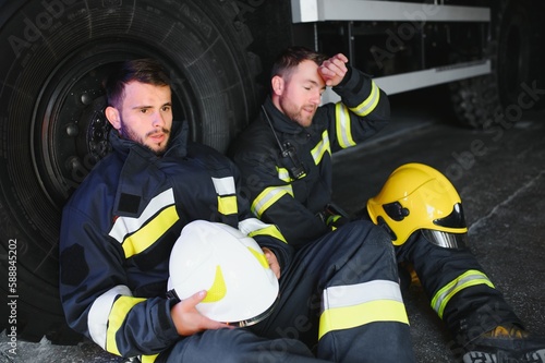 Portrait of two heroic fireman in protective suit and helmet. © Serhii