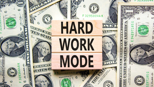 Hard work mode symbol. Concept words Hard work mode on wooden block on a beautiful background from dollar bills. Dollar bills. Business and Hard work mode concept. Copy space.