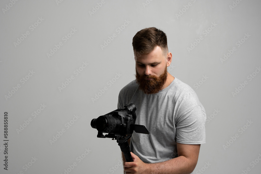 Professional filmmaker with a dslr camera on 3-axis gimbal stabilizer. Filmmaking, videography, hobby and creativity concept. Professional filmmaker with a dslr camera on 3-axis gimbal stabilizer. Filmmaking, videography, hobby and creativity concept.