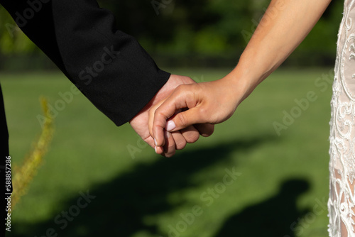 Man and woman holding hands on a green background.