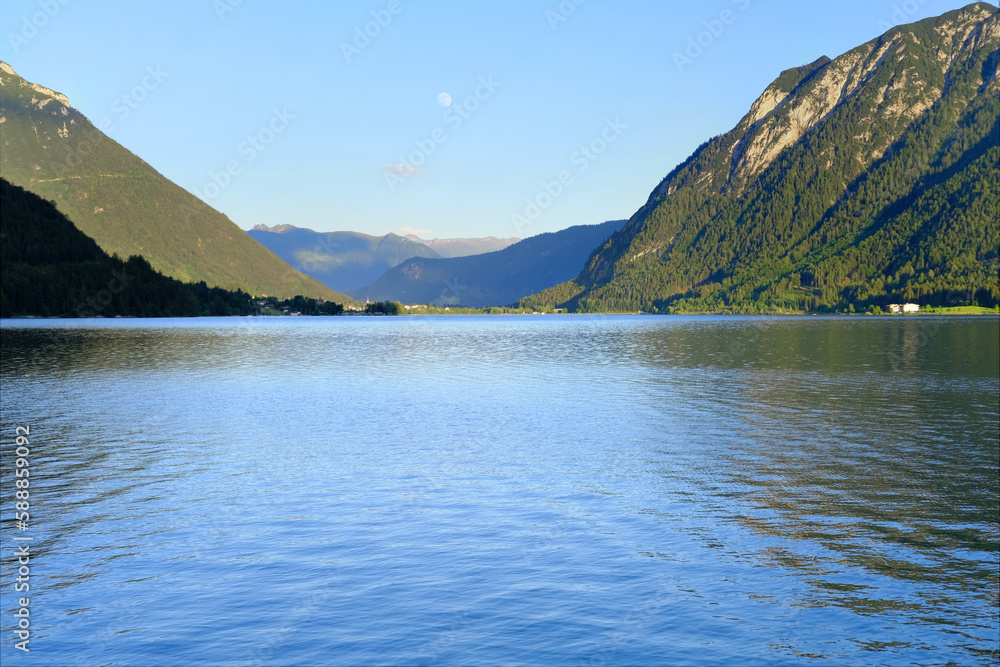 scenic lake Achensee in Austria, green mountains rises above the calm expanse of water, concept of the beauty of nature, vacation by the reservoir, water sports, resort place tyrol