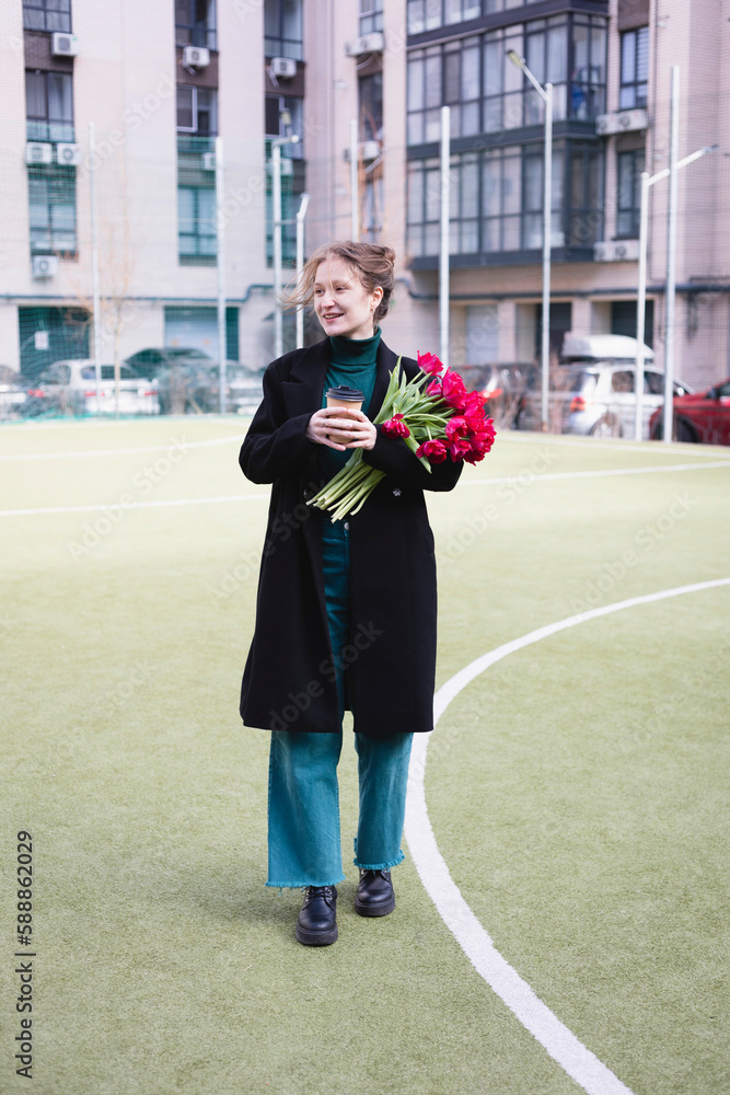 Fototapeta premium girl with a huge bouquet of red tulips