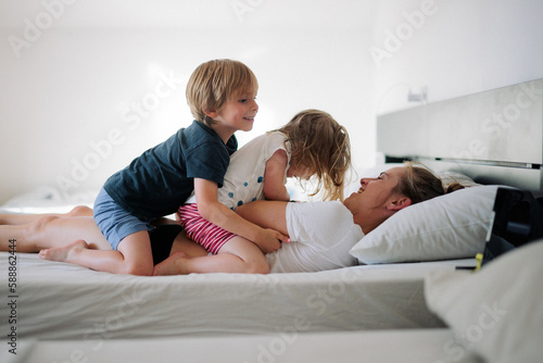 enfants jouent sur le lit avec leurs parents