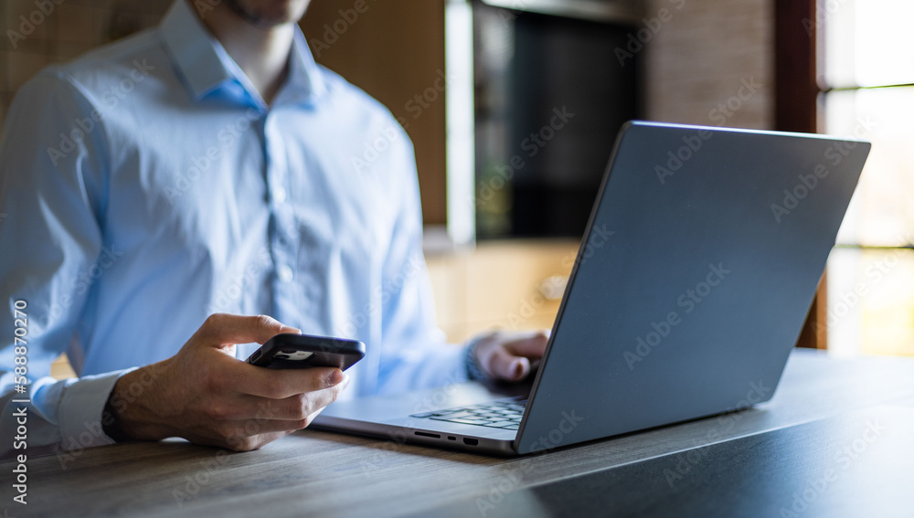 Businessman working on his laptop at the office. Clean office setup. Typing on keyboard in a modern high tech environment. Technology working from home concept Businessman working on his laptop at the office. Clean office setup. Typing on keyboard in a modern high tech environment. Technology working from home concept