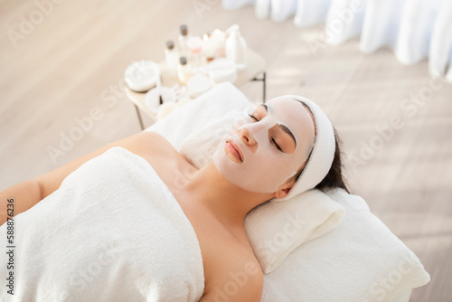 Beauty treatments. Woman lying with sheet moisturizing mask on her face