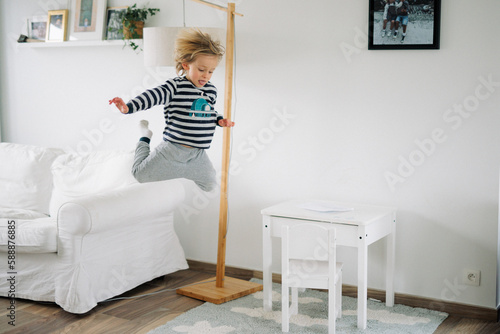 Foto jeune garçon saute du divan