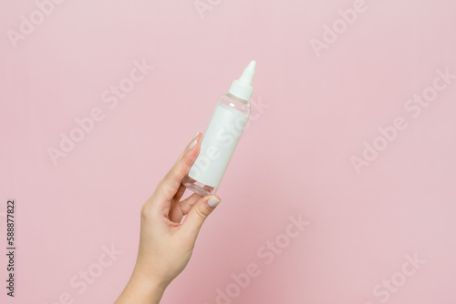 Cosmetic bottle in woman s hand. Cosmetic product branding mockup. Spa beauty treatment concept