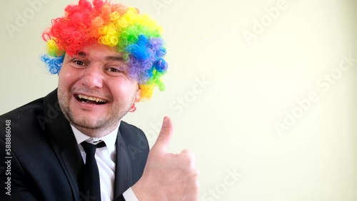 Portrait of crazy happy man in business suit and mask with dyed hair posing on white background.  photo