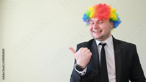 Cheerful smiling man in business suit and mask with dyed hair showing thumb up.  photo