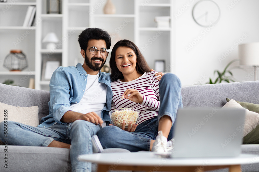 Happy international couple watching movie on laptop at home Happy international couple watching movie on laptop at home